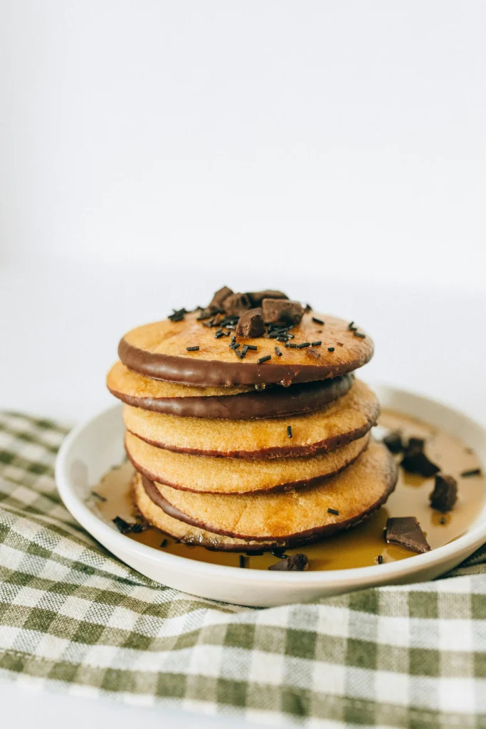 A stack of chocolate chip pancakes on a white plate