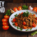 Plate of turkey ground beef garnished with fresh parsley, surrounded by sliced tomatoes, garlic, and herbs on a rustic wooden table