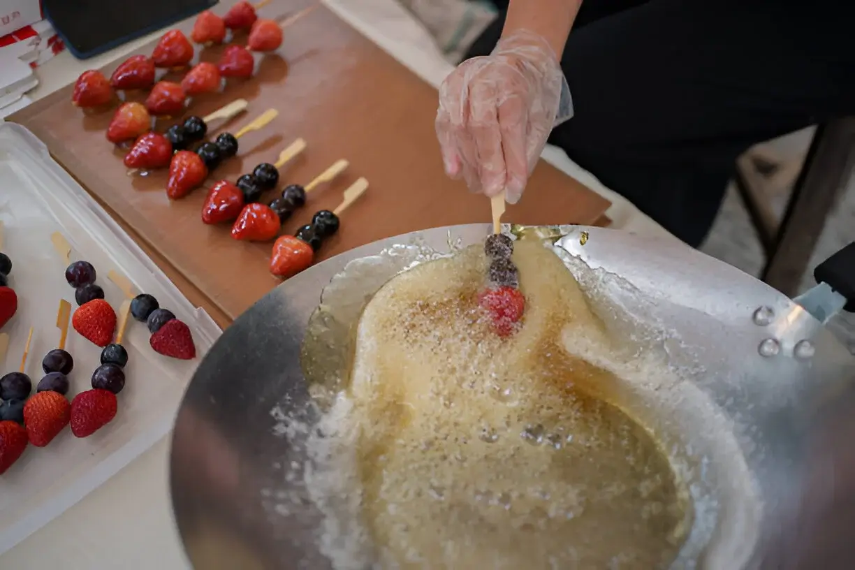 Boiling sugar syrup reaching the hard crack stage for making Tanghulu Chinese Candied Fruit